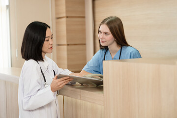 Asia doctor woman working and talking with Caucasian woman medical student at hospital	