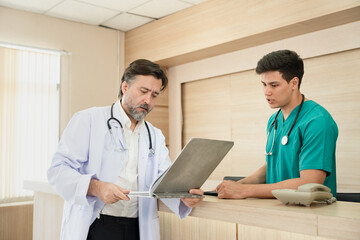 Major Caucasian man doctor with medical student use tablet computer working at hospital	
