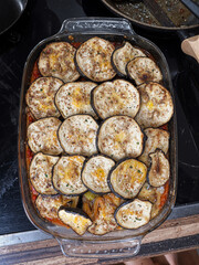 A glass baking dish filled with a homemade Mediterranean-style vegetable casserole, likely a variation of moussaka or eggplant parmigiana.