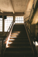 Obraz premium scalinata in cemento che conduce ad un piano superiore, all'interno di un edificio vecchio ed abbandonato