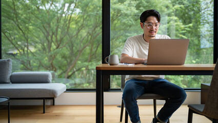 Man Working from Home on Laptop with Green View