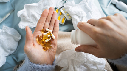 Woman with orange and white medical pill supplements taking medicine to get over symptoms of fever,...