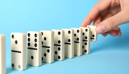 A hand placing a domino in a row