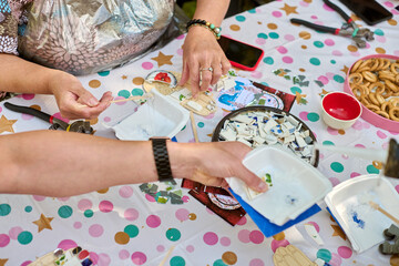 Crafting mosaic art at colorful table. Ceramic fragments, hands working, snacks nearby. Playful...