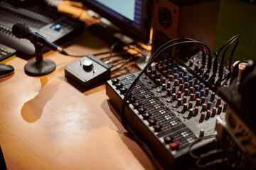 Audio mixing console with microphone in contemporary recording studio setting, showcasing intricate...