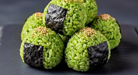 Obraz premium Gourmet Green Rice Sushi Balls with Seaweed on Dark Stone