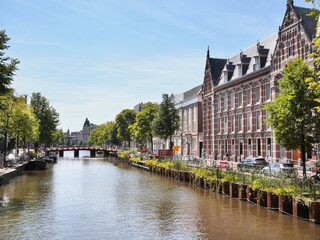 Kloveniersburgwal Canal next to the Oost-Indisch Huis as seen from the Bushuissluis Bridge between Oude Hoogstraat and Nieuwe Hoogstraat during a summer season in the center of Amsterdam, Netherlands
