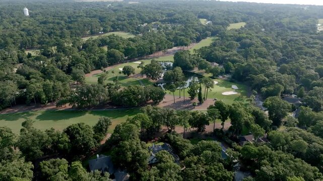A forested golf course winds through Hilton Head, blending greens, water features, and fairways into a serene, nature-rich playing experience.