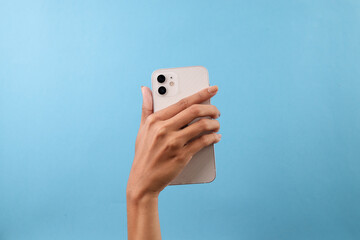 Woman Hand Holding Smartphone With Dual Cameras Isolated On Blue Background