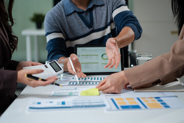 Businessmen write project ideas and use laptops to edit papers for brainstorming sessions with...