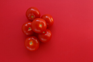 Fresh red tomatoes on red background