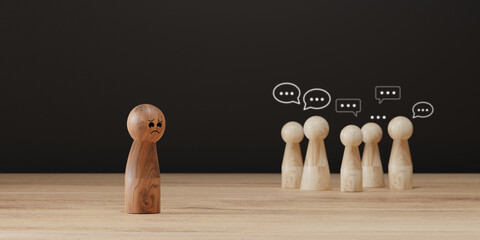 Sad wooden figure excluded from group. Concept of bullying, discrimination, isolation, loneliness,...