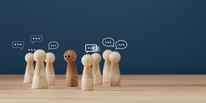 Sad wooden figure excluded from group. Concept of bullying, discrimination, isolation, loneliness, and mental health in society, workplace or school.