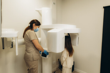 Dentist taking a panoramic dental x-ray of little girl