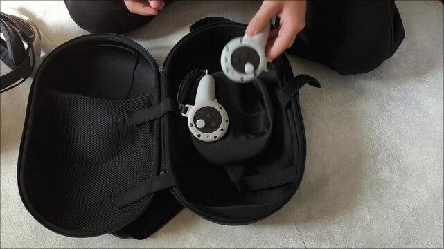 Men's hands open and fold viar glasses into a case with VR glasses on a gray background. Teenagers and video games. Virtual reality.