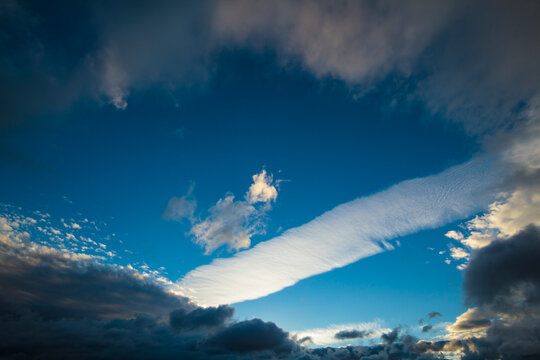 Contails above the North Cascades National Park, a wide strip of condensation through a blue sky.