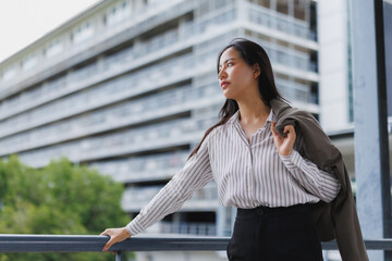 Businesswoman leaning on railing and looking away in urban setting