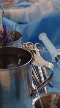 Surgeon tools set on tray closeup. Sterile instruments for coronary artery bypass surgery against working doctor in hospital. Medical equipment