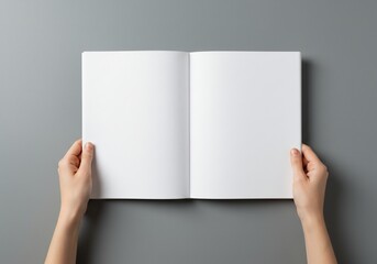 Blank book held open showing empty white pages against gray background