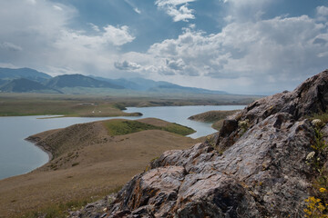 Fototapeta premium Bestyubinskoye Reservoir is a picturesque place for lovers of a quiet holiday in nature, surrounded by hills resembling a layered cake and mountain peaks, 