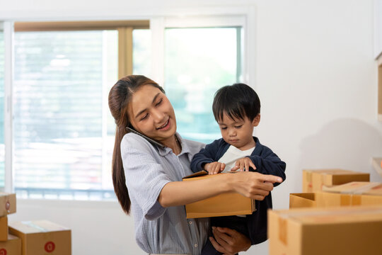 Sell Online: Mother and son exploring packages in home office