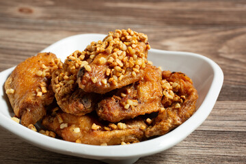 A closeup view of a bowl of garlic chicken wings.