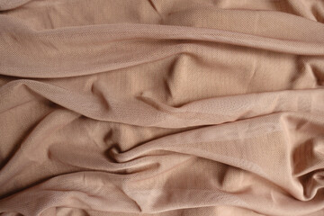 Folded pastel beige unprinted polyester mesh fabric
