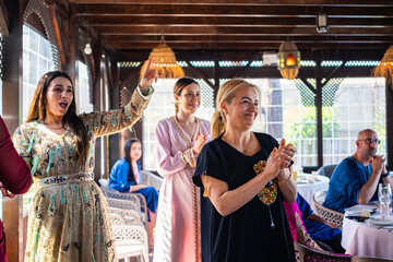 Multicultural group of people engage in lively Arab celebration at a vibrant gathering, showcasing...