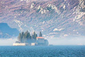 St. George Monastery island at sunrise with morning mist and mountainous backdrop, Kotor Bay,...
