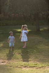 Two young children exploring nature in golden sunlight