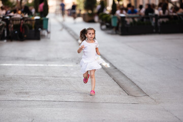 Little girl running on a city street in summertime