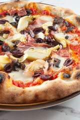 A closeup view of a pizza capricciosa.