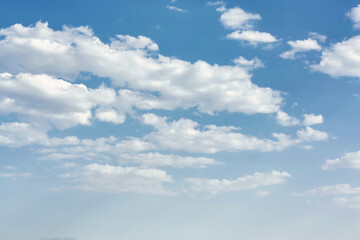 Bright blue sky with soft scattered white clouds on a sunny day