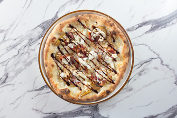 A top down view of a pear and burrata pizza.