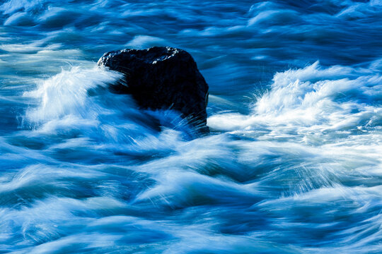 Elwha River flowing around a rock in mid stream.