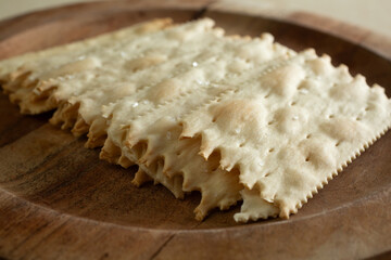 A closeup view of a pile of flatbread crackers, on a plate.