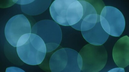 Teal blue and green outoffocus round shapes against a dark background - Powered by Adobe