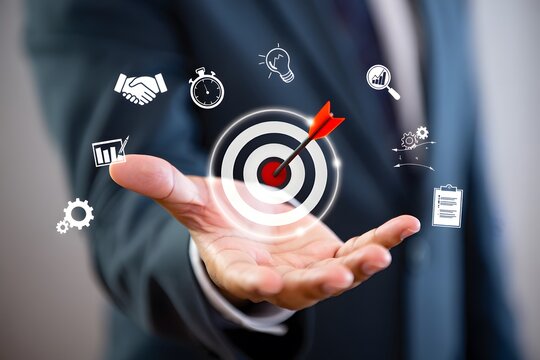 Businessman holding a target with an arrow in the bullseye surrounded by business icons