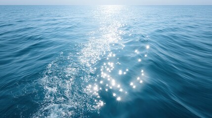 Tranquil ocean surface with shimmering sunlight reflections, creating a serene atmosphere and inviting calmness in the vast blue waters