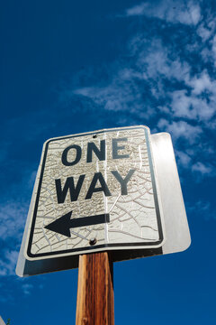 Low angle view of road sign saying One Way with a directional arrow.