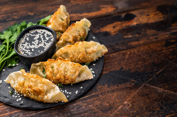 Fried Gyoza on plate with sauce, Japanese Dumplings with shrimps and vegetables. wooden background....