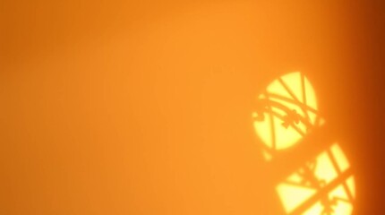 Warm Sunlight Shadow: Abstract of sunlit architectural shadows casting intricate patterns against a warm orange wall, evoking feelings of serenity, warmth, and the passage of time.