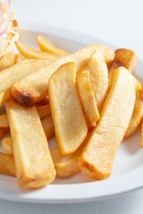 A closeup view of a pile of thick cut french fries.