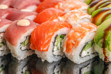 An assorted sushi platter showcases vibrant rolls topped with tuna, salmon, shrimp, and avocado, reflecting freshness, variety, and culinary artistry