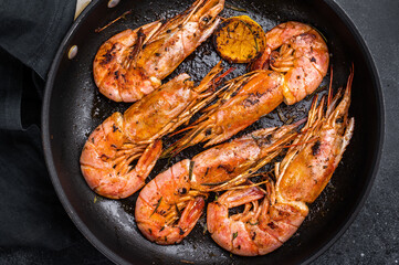 Pan fried red Argentine shrimps, Prawns Langostino Austral with herbs. black background. top view