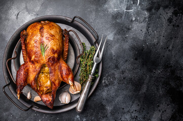 Roasted whole goose on steel tray. black background. top view © Mironov