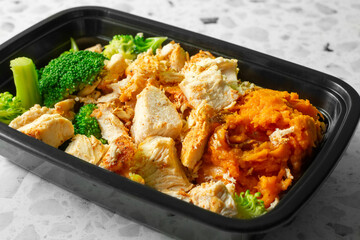 A view of a meal prep entree of chicken and mashed sweet potato.