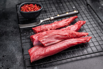 Raw lamb tenderloin fillet meat, fresh mutton. black background. top view