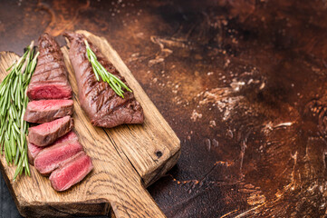 Grilled Lamb tenderloin steak, roast mutton fillet meat with herbs. brown background. top view