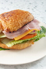 A view of a ham and cheese croissant sandwich.